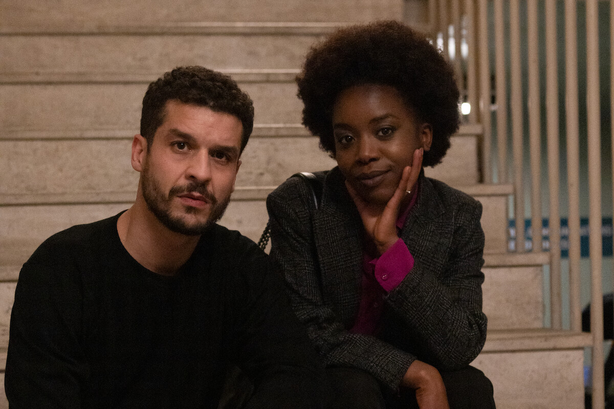 Martha Canga Antonio as Fleur sits on a staircase in Season 3 of ‘Lupin.’