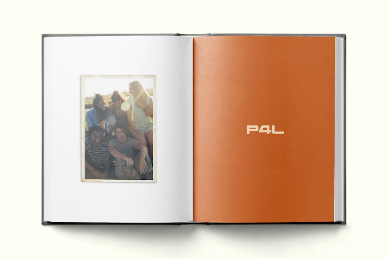 A photo book open to a page showing a group of friends outdoors in sunlight, sitting closely and smiling, with an adjacent orange page featuring the text "P4L."