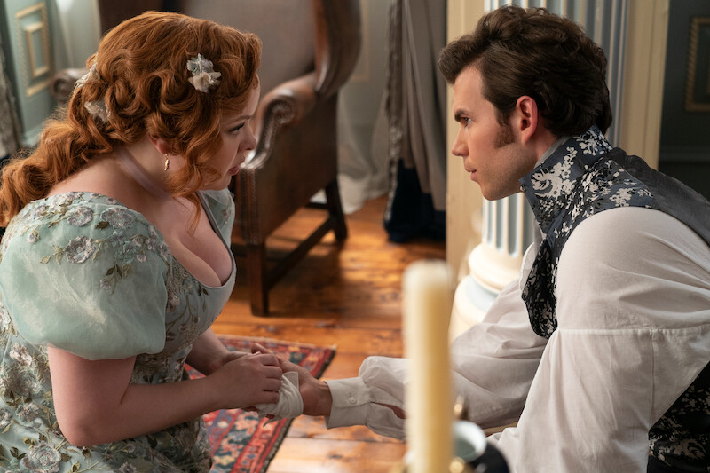 Nicola Coughlan as Penelope Featherington and Luke Newton as Colin Bridgerton look into each other's eyes in season 3 of 'Bridgerton'