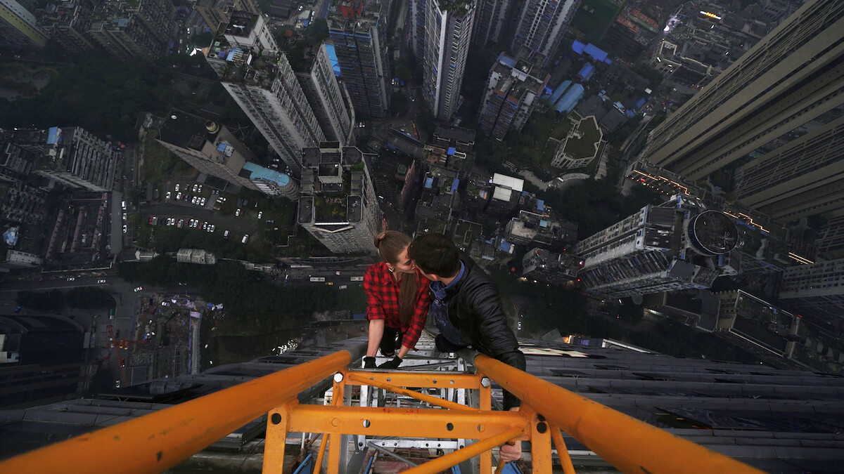 Ivan Beerkus and Angela Nikolau kissing while climbing a crane