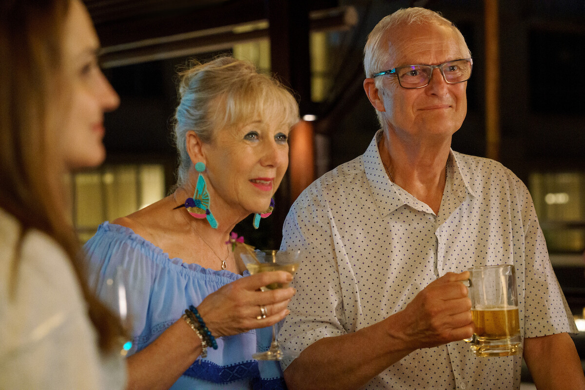 A man and woman hold drinks in a still from ‘A Tourist’s Guide to Love.'