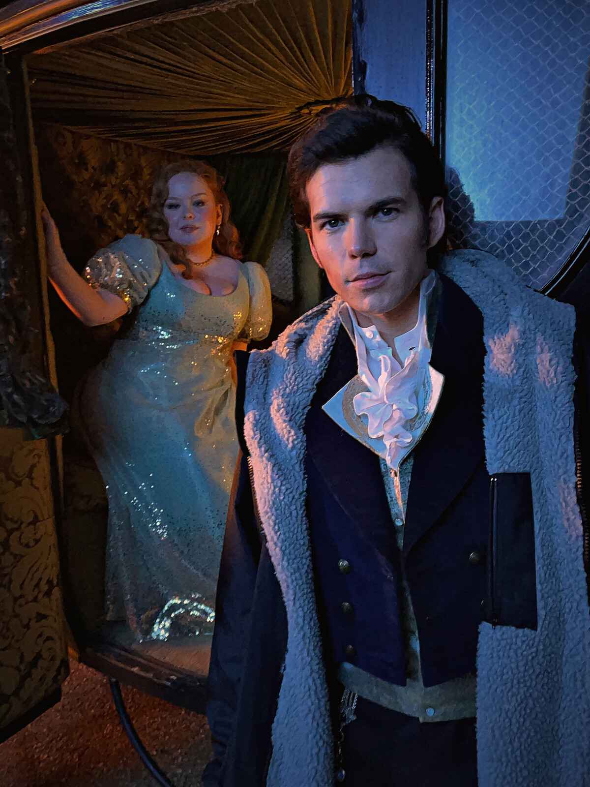 Bastidores de Nicola Coughlan, como Penelope Featherington, e Luke Newton, como Colin Bridgerton, em uma carruagem na temporada 3 de ‘Bridgerton’.