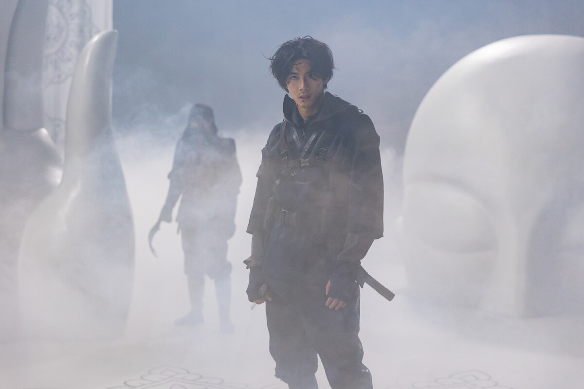 Kento Kaku as Haru Tawara stands in front of Takayuki Yamada in a still image from the series ‘House of Ninjas’