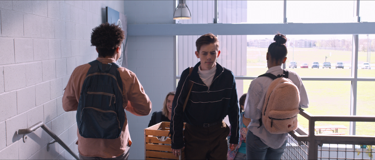 Dunkleman carrying his milk crate on the stairs at his high school in Tall Girl