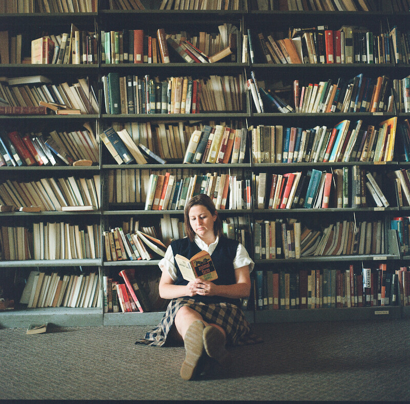 Katherine Kubler in front of a wall of books at The Academy at Ivy Ridge.