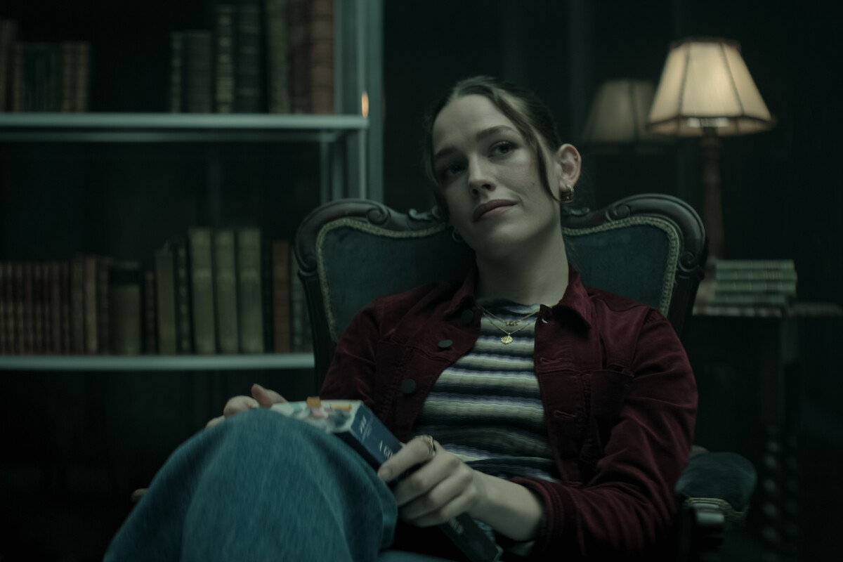 Victoria Pedretti as Love Quinn sits in the glass cage in You Season 4.