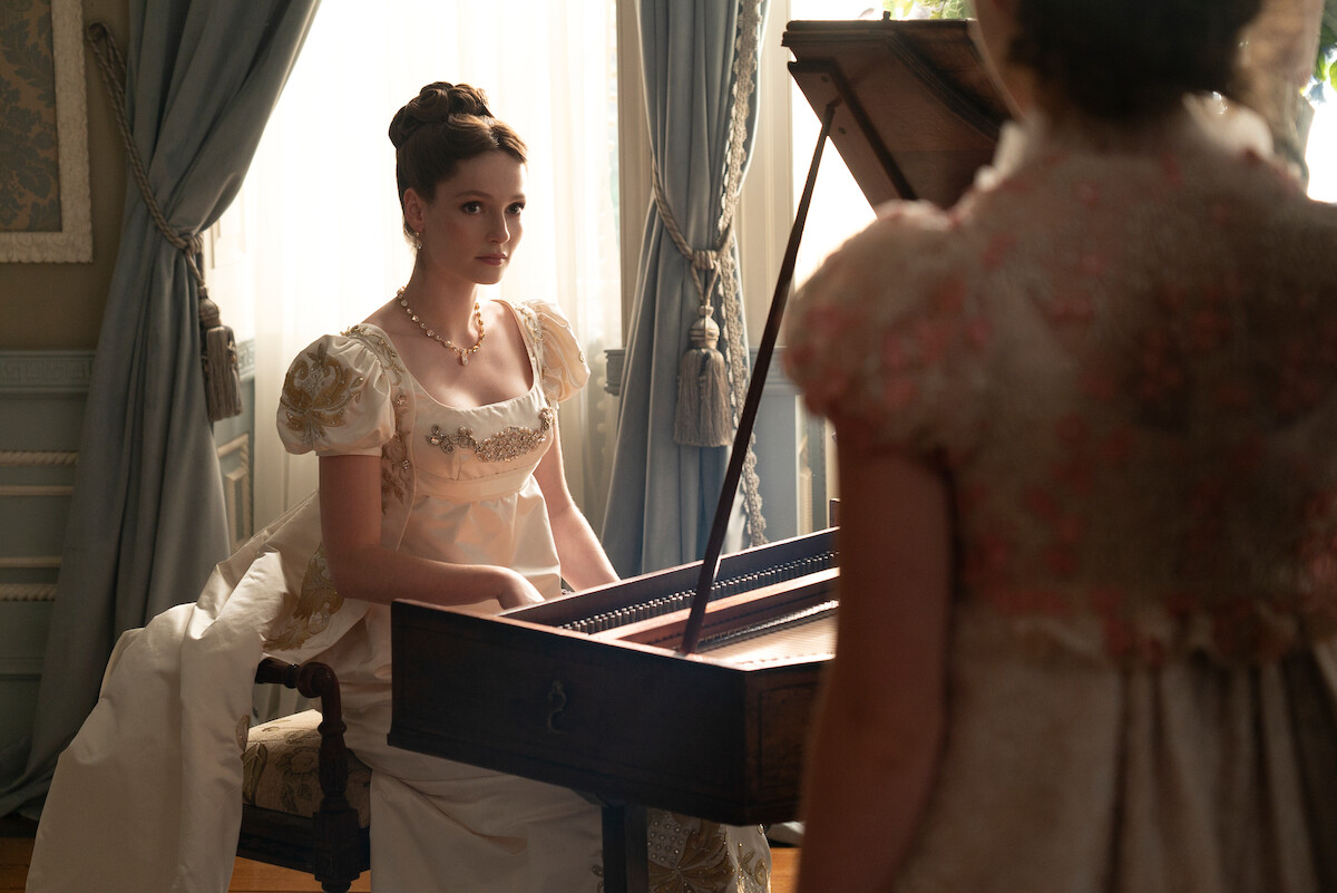 Hannah Dodd como Francesca Bridgerton sentada ao piano na temporada 3 de ‘Bridgerton’.