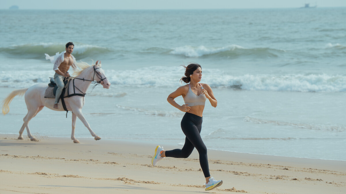 Ishaan Khatter as Aviraaj Singh rides a horse on a beach as Bhumi Pednekar as Sophia Shekhar jogs ahead of them in an image from ‘The Royals.’