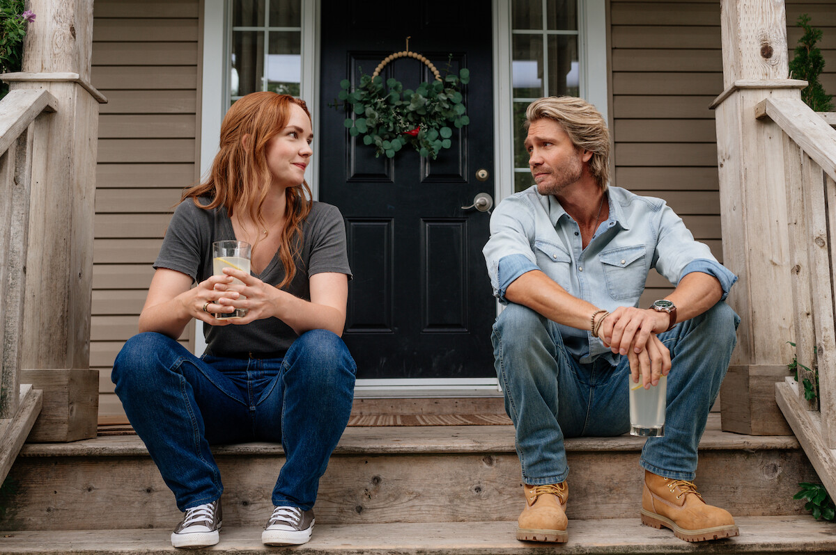 Morgan Kohan as Maggie and Chad Michael Murray as Cal sit on a porch drinking lemonade in a production still from ‘Sullivan’s Crossing’.