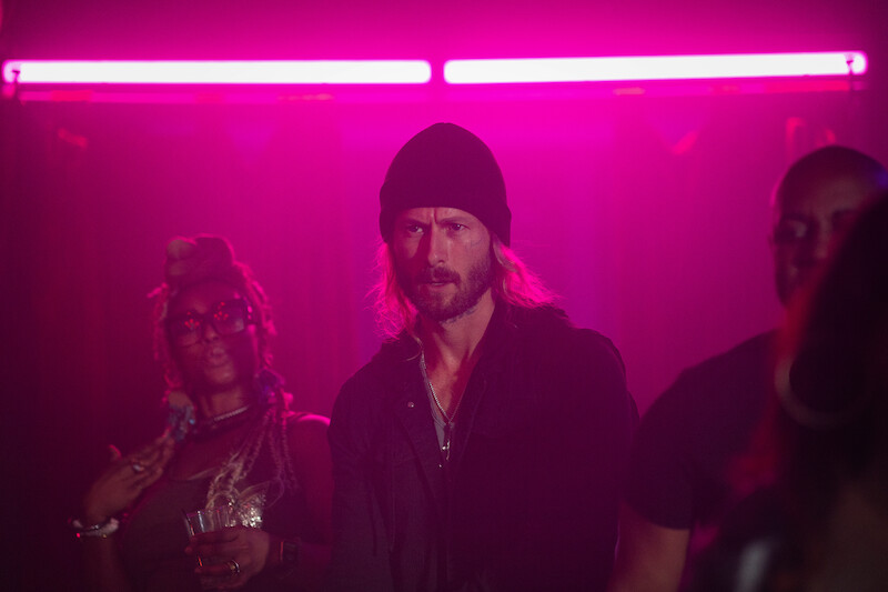 Gary Johnson (Glen Powell) undercover in a pink-hued club.