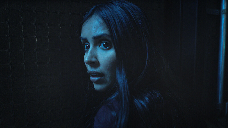 A woman standing in the shadows