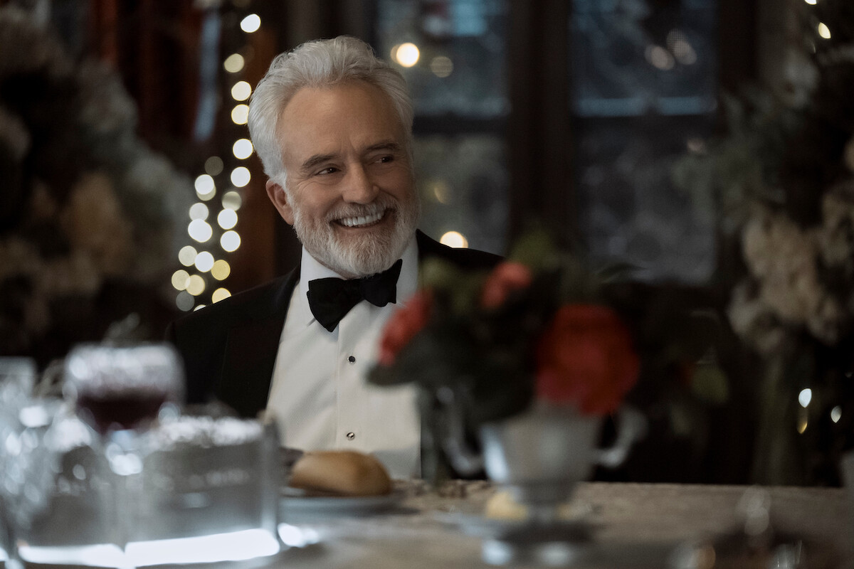 Bradley Whitford as Todd Penn smiles while dressed in a tuxedo and seated at a formal dinner.
