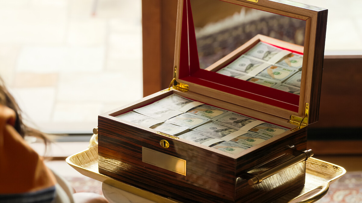 A box filled with money is carried on a tray.