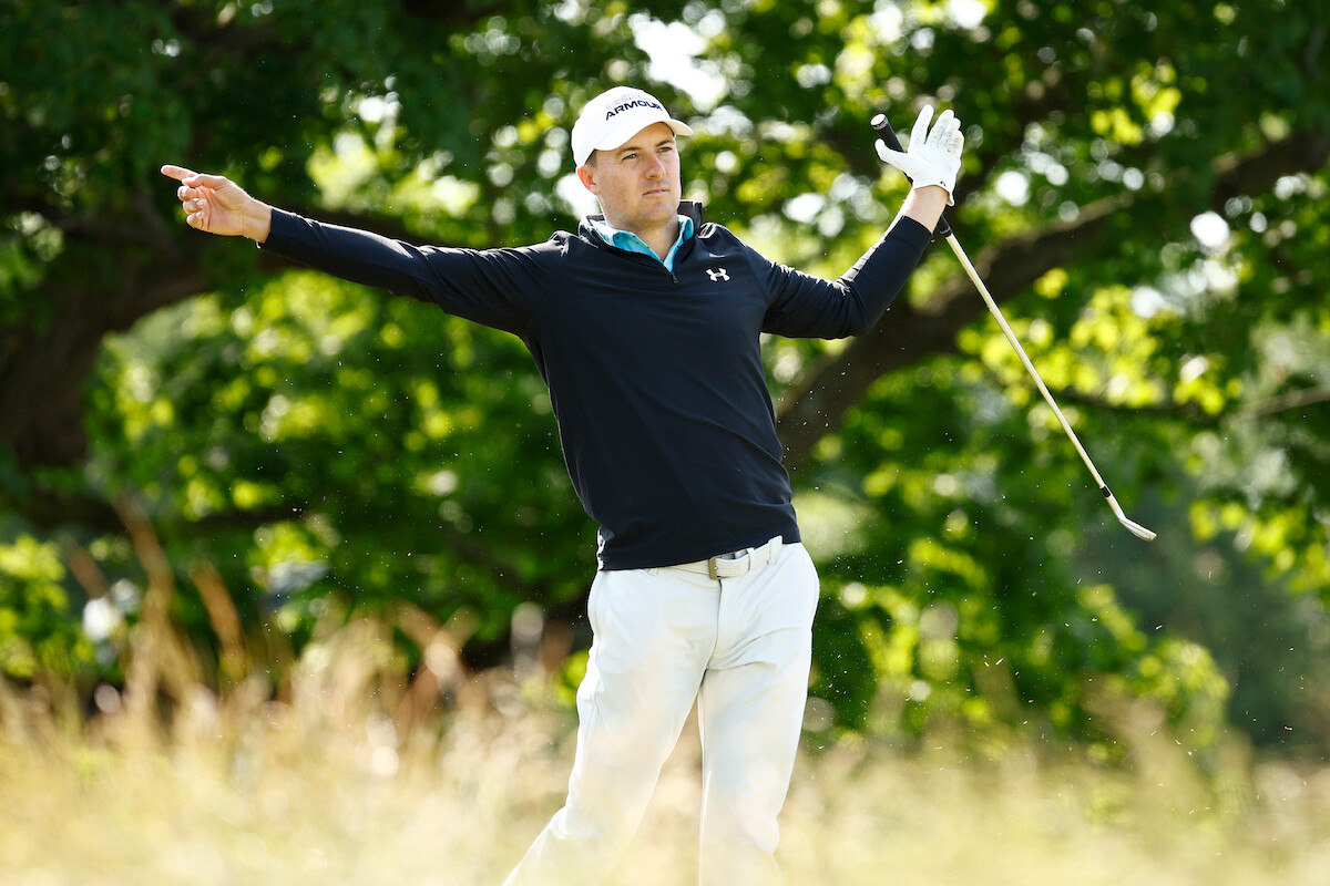 Golfer Jordan Spieth watches his ball fly after a swing.