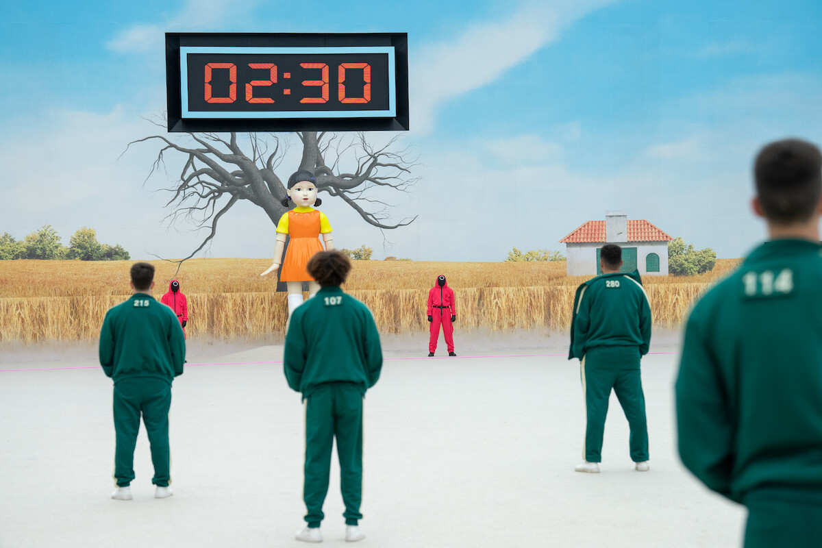 ‘Squid Game: The Challenge’ contestants play the Red Light, Green Light challenge as the doll (Young-hee) watches them.