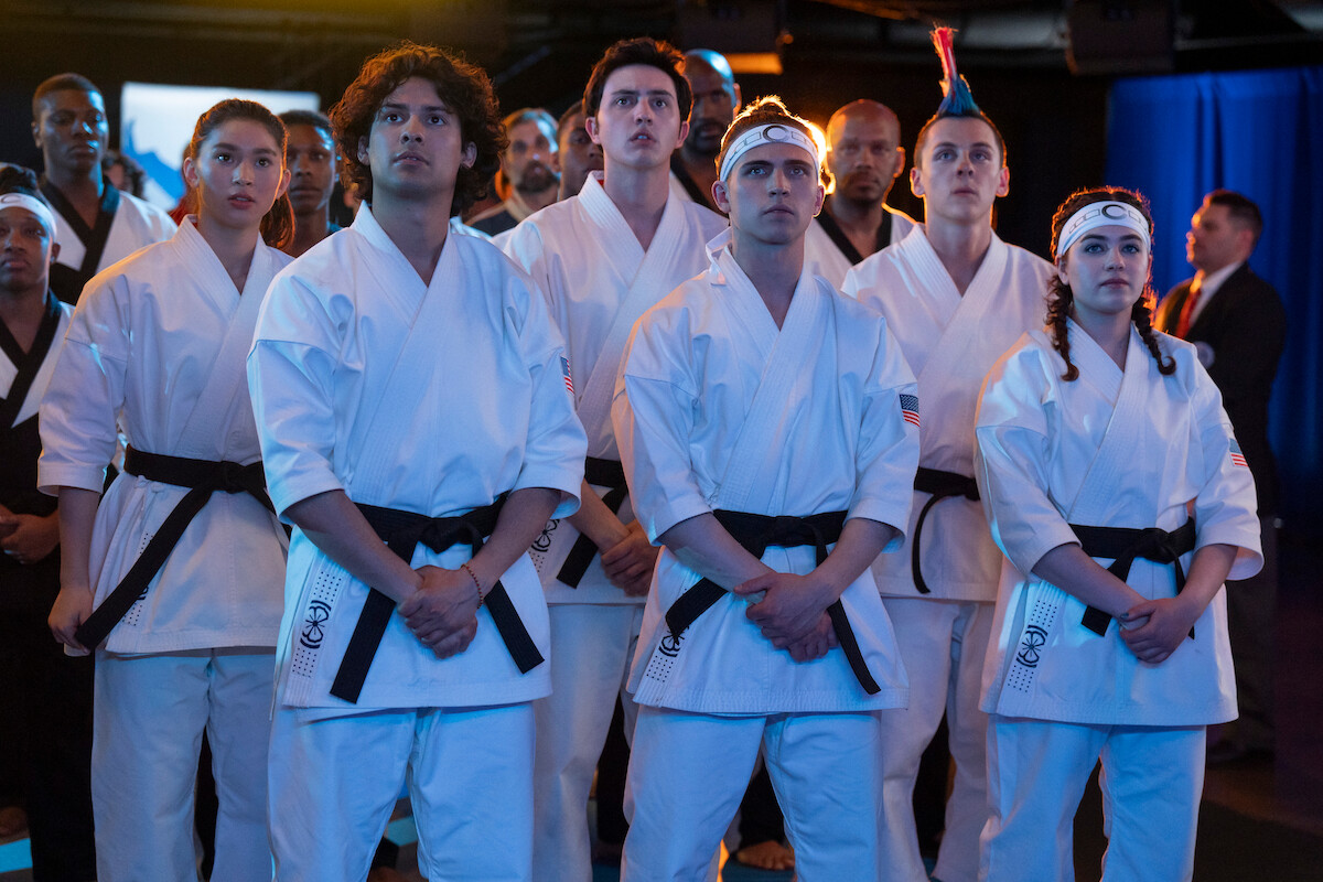 Oona O’Brien as Devon, Xolo Maridueña as Miguel Diaz, Gianni DeCenzo as Demetri, Jacob Bertrand as Eli 'Hawk' Moskowitz, and Mary Mouser as Samantha LaRusso stand together in karate uniforms in Season 6 of ‘Cobra Kai.’