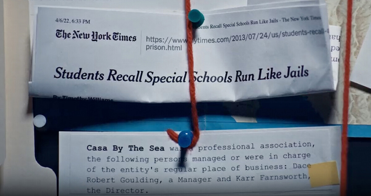 Close up of newspaper clippings attached to a cork board.