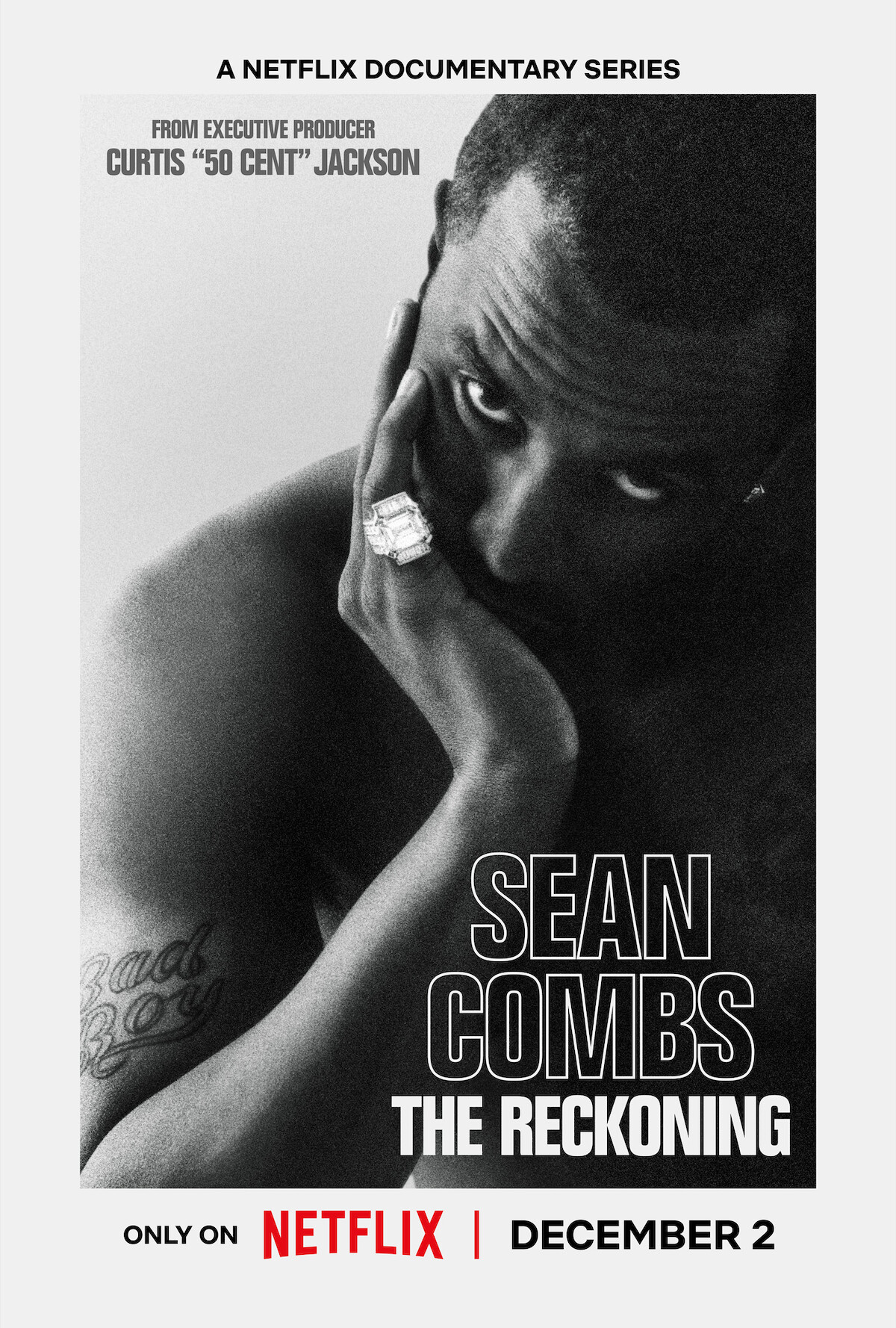 Black-and-white poster for a Netflix documentary series featuring a contemplative man with a tattoo, large ring, and his hand near his face, titled "Sean Combs The Reckoning," releasing December 2, mood is serious and introspective.