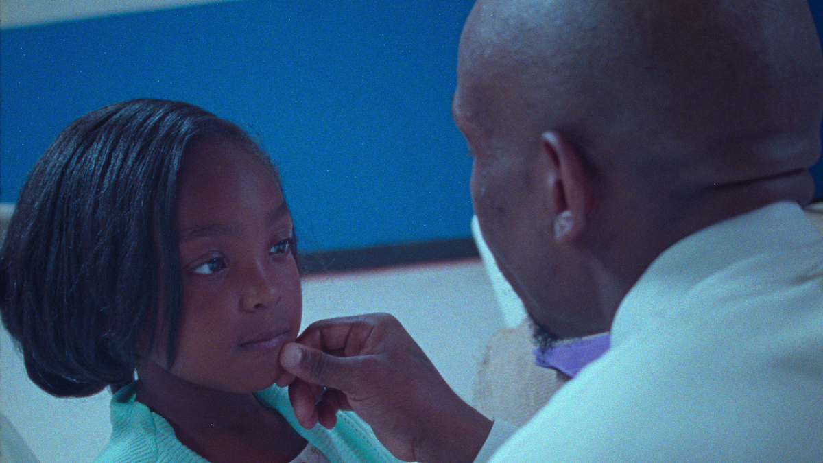 A man puts his hand to his daughters chin.