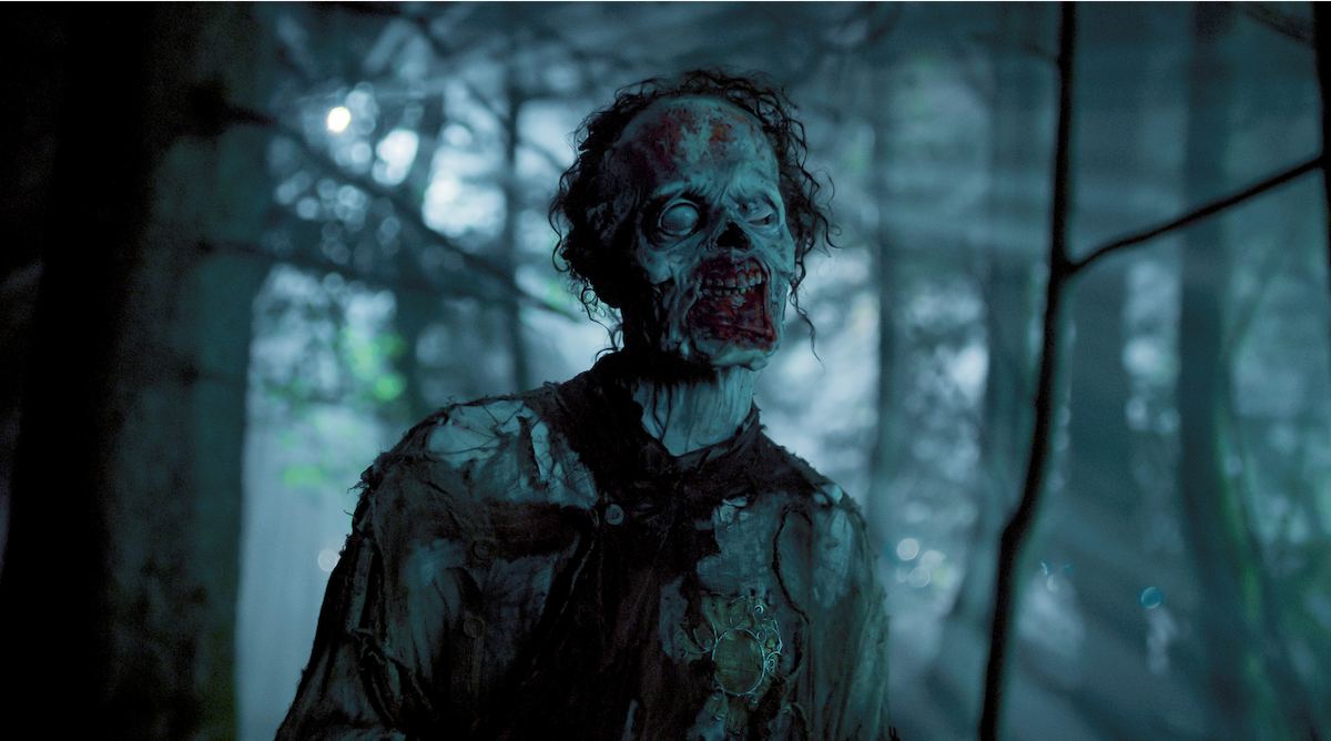 Owen Painter as Slurp in a dark forest in ‘Wednesday’ Season 2.