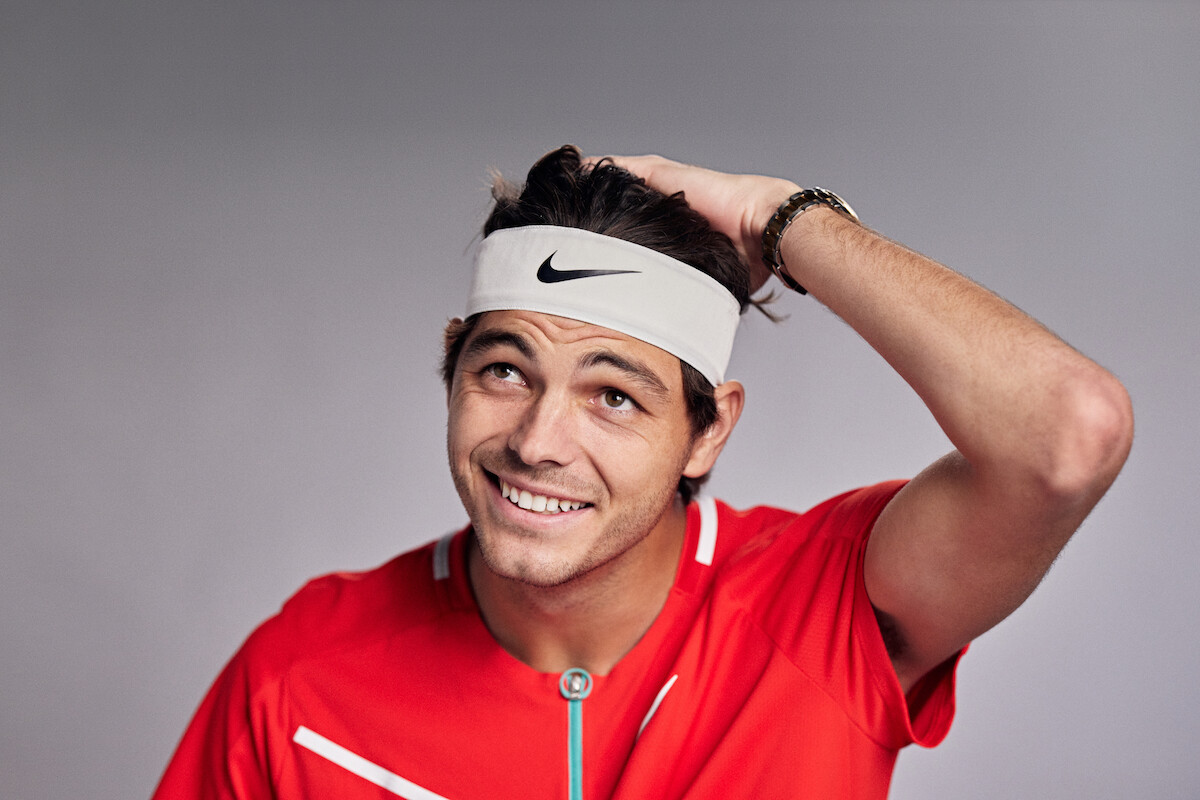 Taylor Fritz looks upward with a hand on his head.