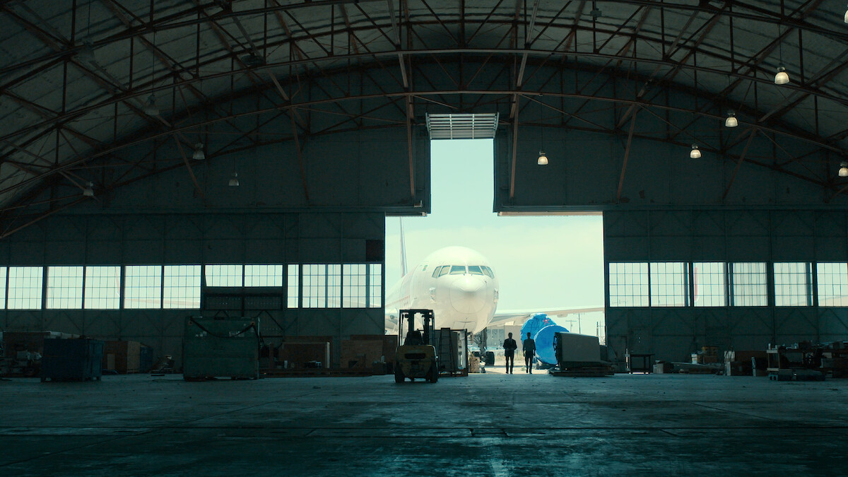 Donald Schmitt and Kevin Randle in an airplane hangar.