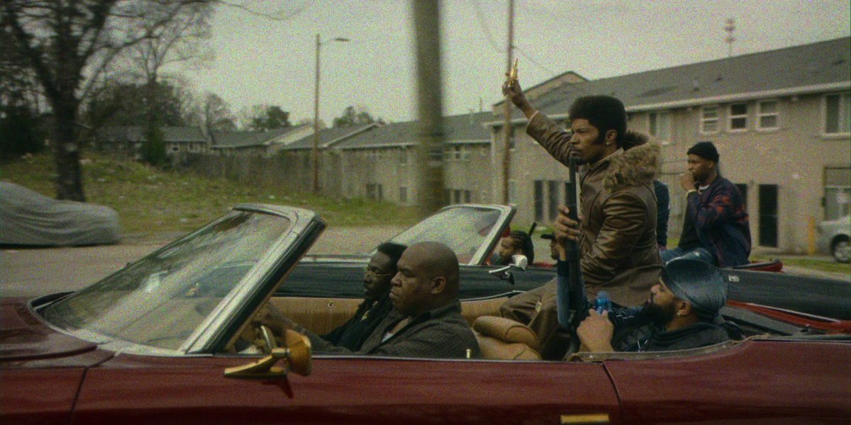 Jamie Foxx as Slick Charles rides atop a tricked-out lowrider. 