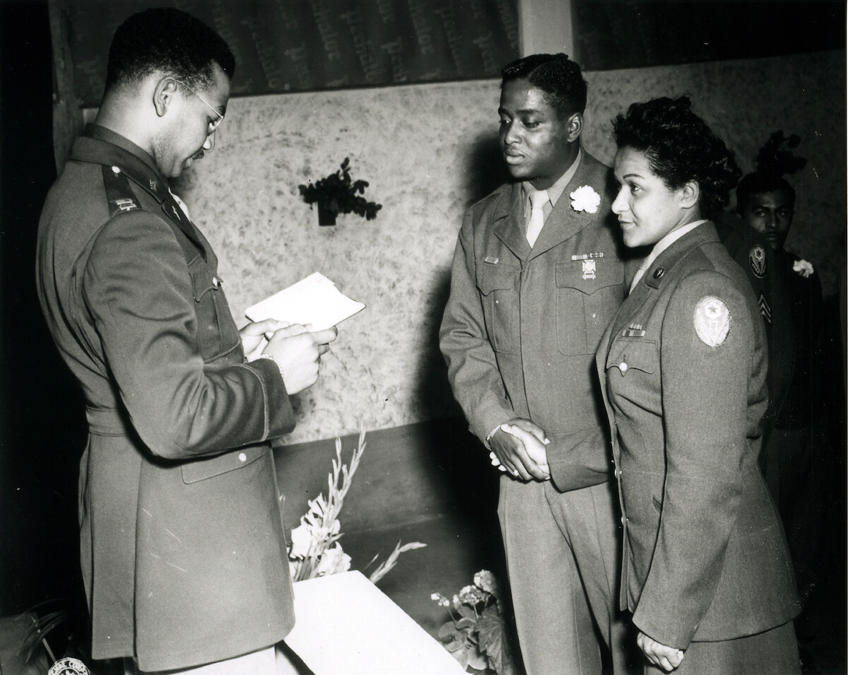 Chaplain William J. Green reads the benediction at the marriage ceremony of Private First Class Florence A. Collins, of the 6888th Postal Directory Battalion, to Corporal William A. Johnson of the 1696th Labor Supervision Company, in Rouen, France, August, 1945. This is the first African American marriage to be performed in the European Theater of Operations.
