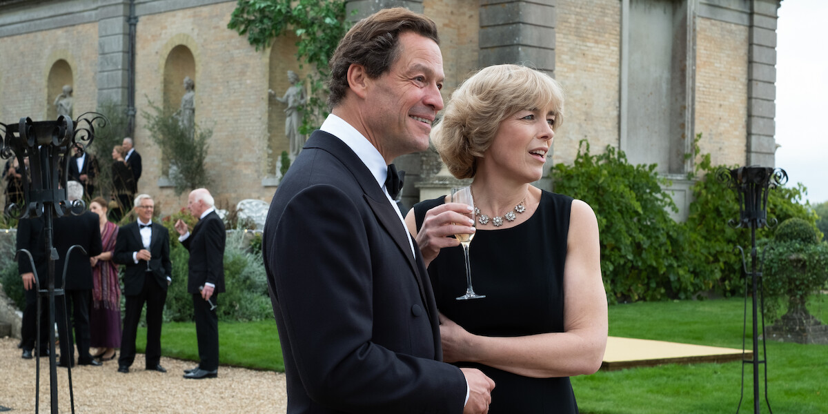 Charles and Camilla embrace outside while holding a glass of Champagne.