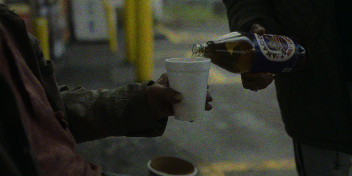 Fontaine pouring a 40-ounce of Anaconda malt liquor into someone’s cup. 