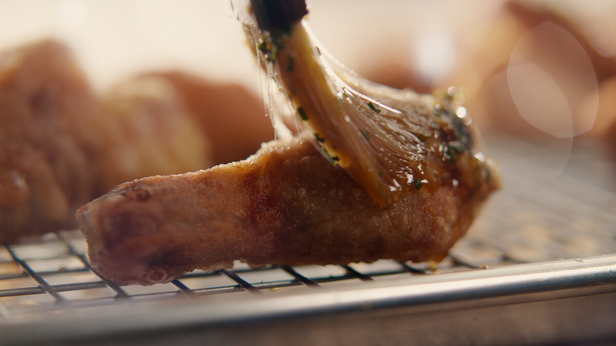Korean crying tiger sauce being spread onto fried chicken.