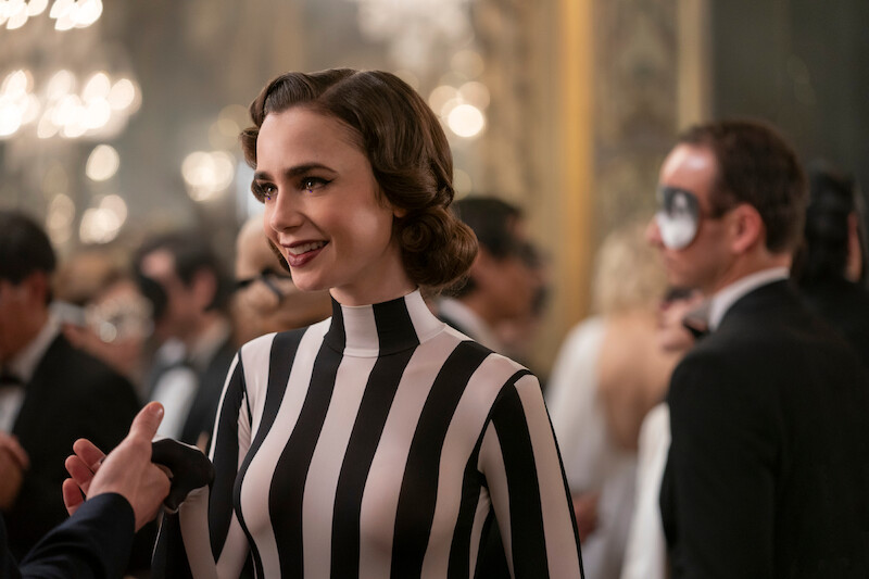 Lily Collins as Emily wears a black and white striped dress in Season 4 of 'Emily in Paris'