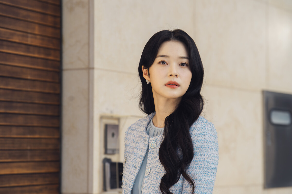 Uma mulher sul-coreana de cabelos pretos veste um sobretudo cinza