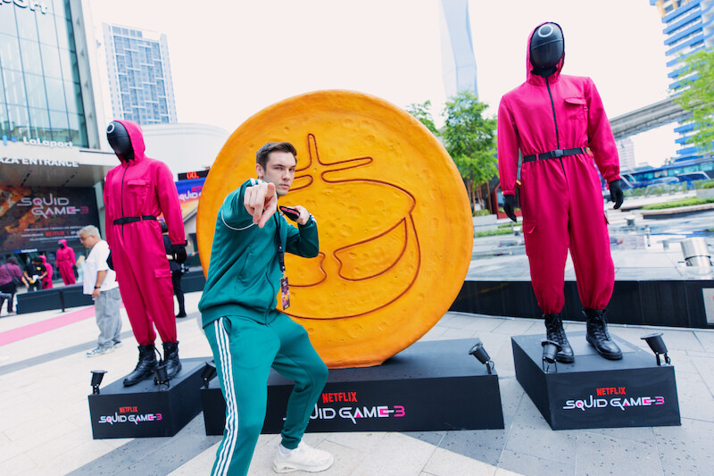 A fan poses in front of a dalgona at a 'Squid Game' Season 3 event in Kuala Lumpur, Malaysia.