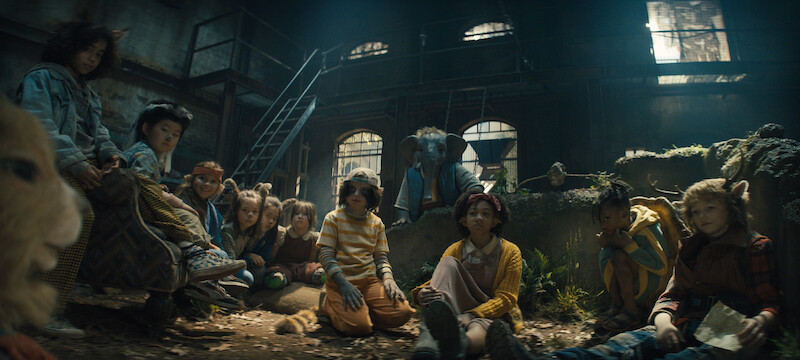 Multiple hybrid children sit in a dark room. 