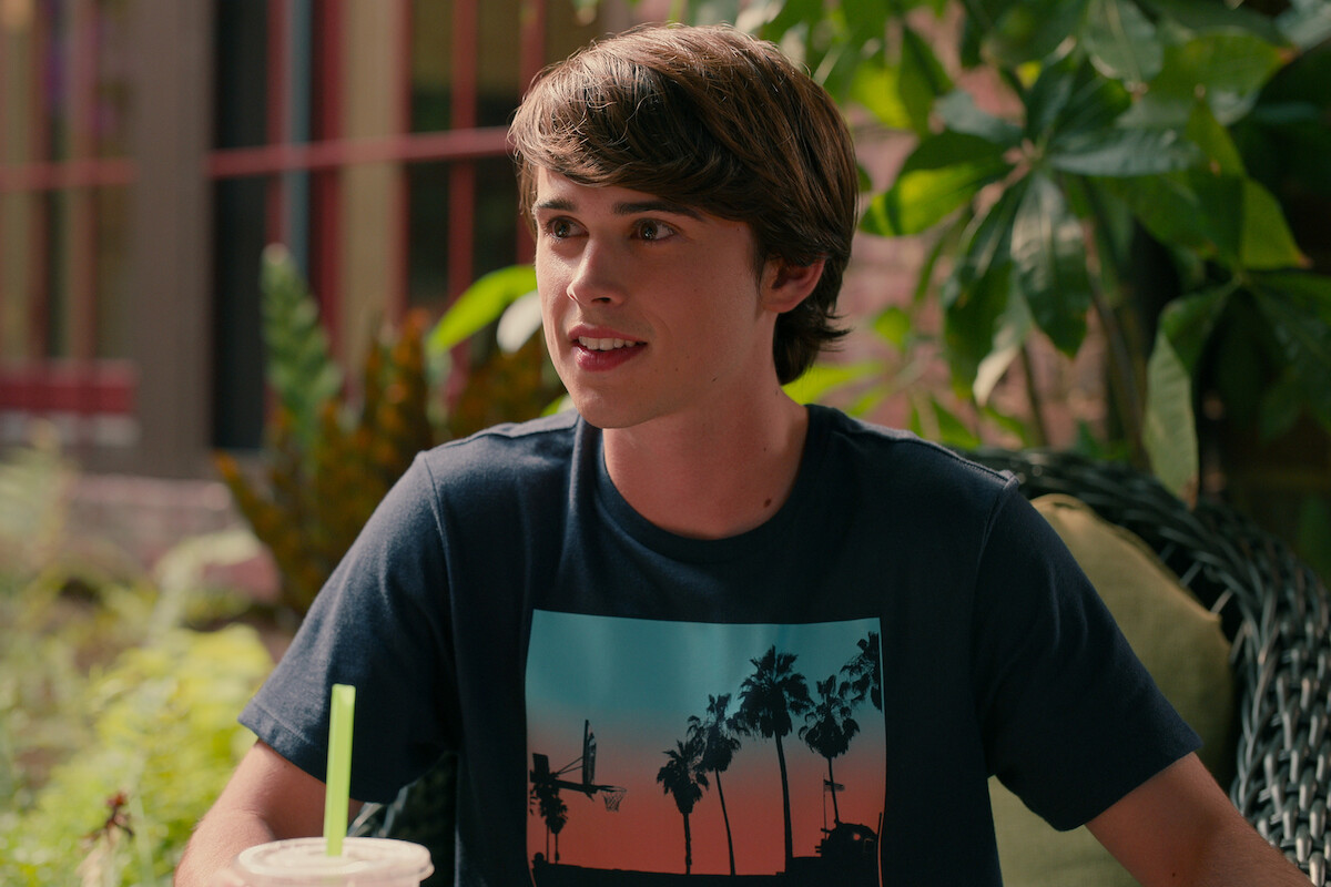 Logan Allen as Kyle sits outside smiling in Season 3 of ‘Sweet Magnolias.’