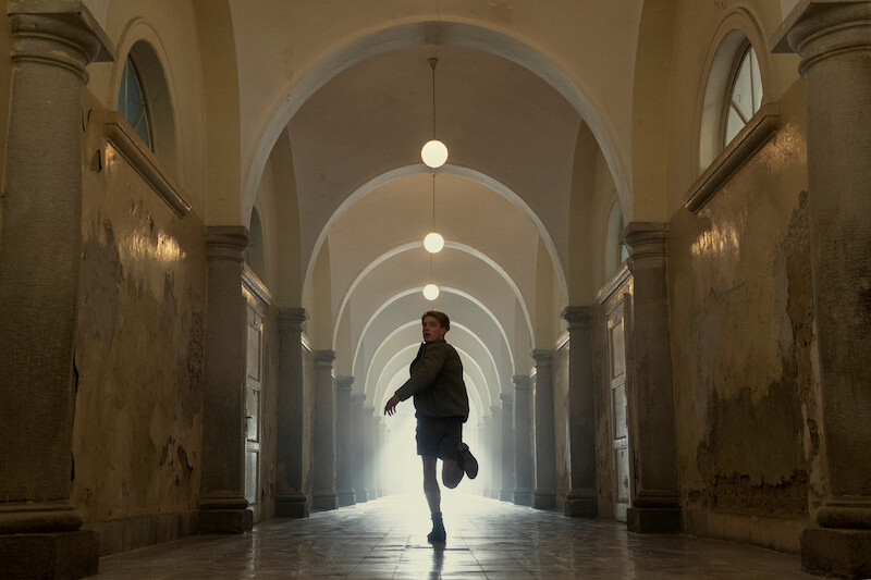 Louis Hofmann as Werner Pfennig running down a long hallway. 