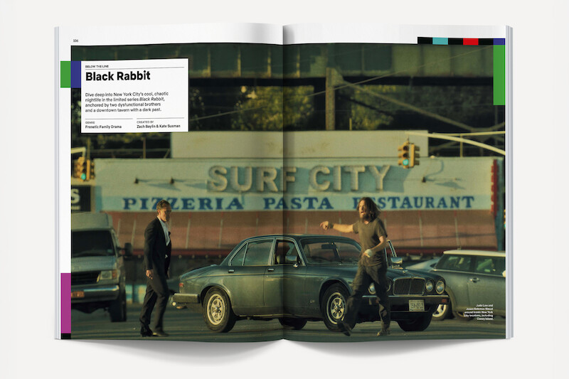 Two men stand by a vintage car on a city street in front of the Surf City Pizzeria Pasta Restaurant sign, with traffic lights and other vehicles, creating an urban, possibly tense atmosphere.