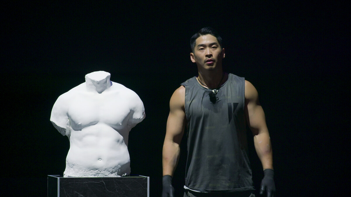 Winner Woo Jin-yong stands next to his bust.