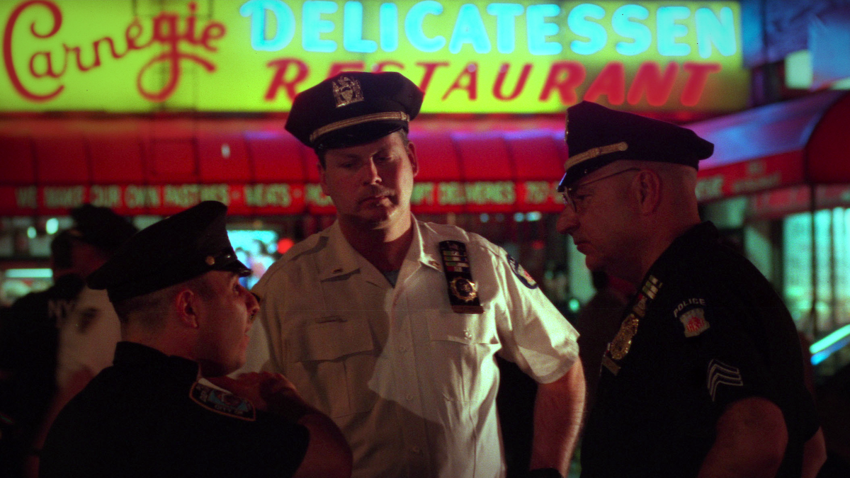 Police officers standing in front of the Carnegie Deli.