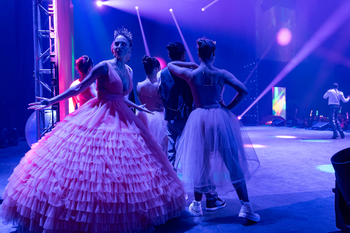 Genesis Rodriguez as Isa stands backstage wearing a gown in Season 1 of ‘Neon.’