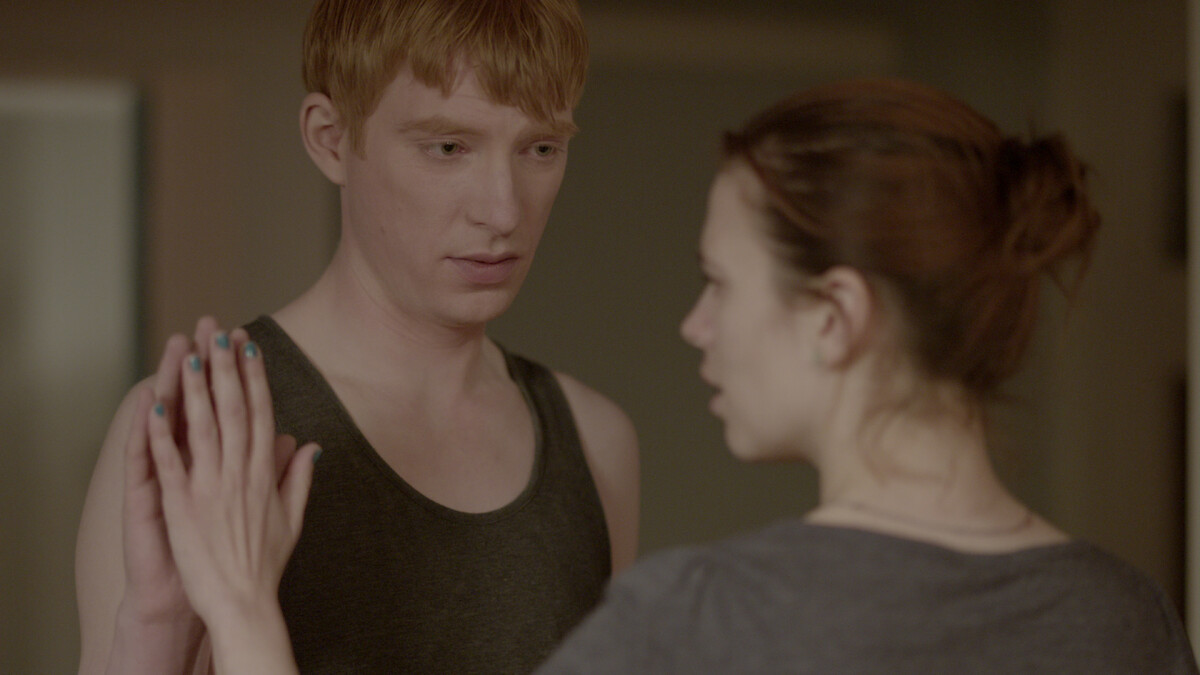 A man and woman face each other and touch palms in Season 2 of 'Black Mirror'