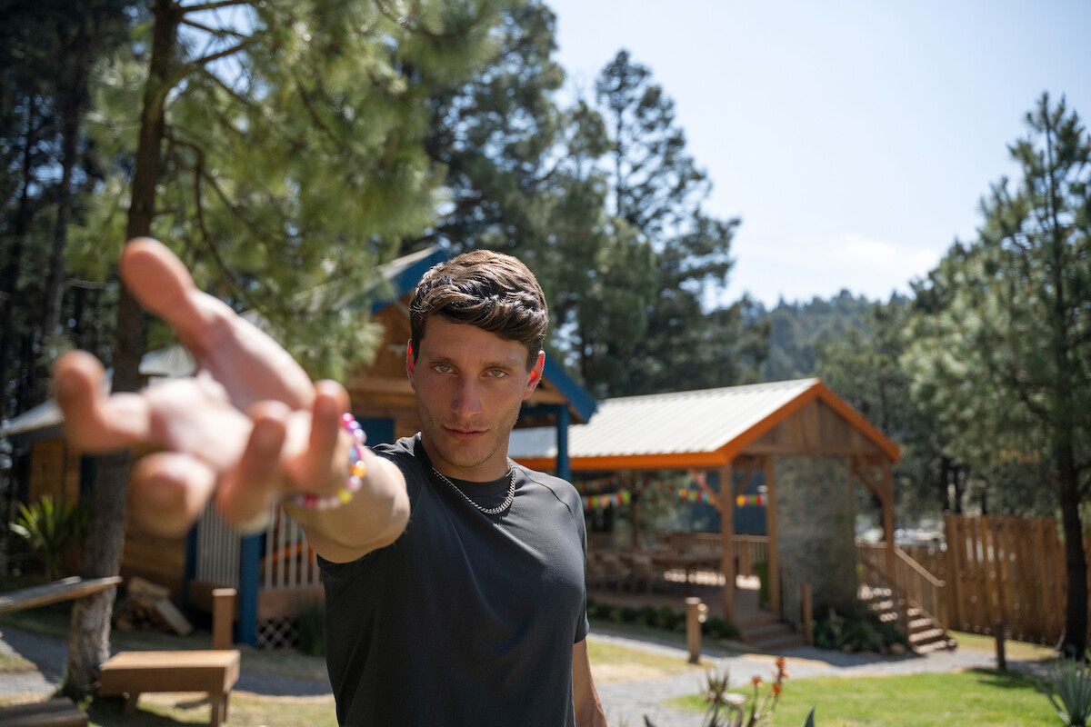 Lorenzo Nobilio raises an open hand towards the camera.