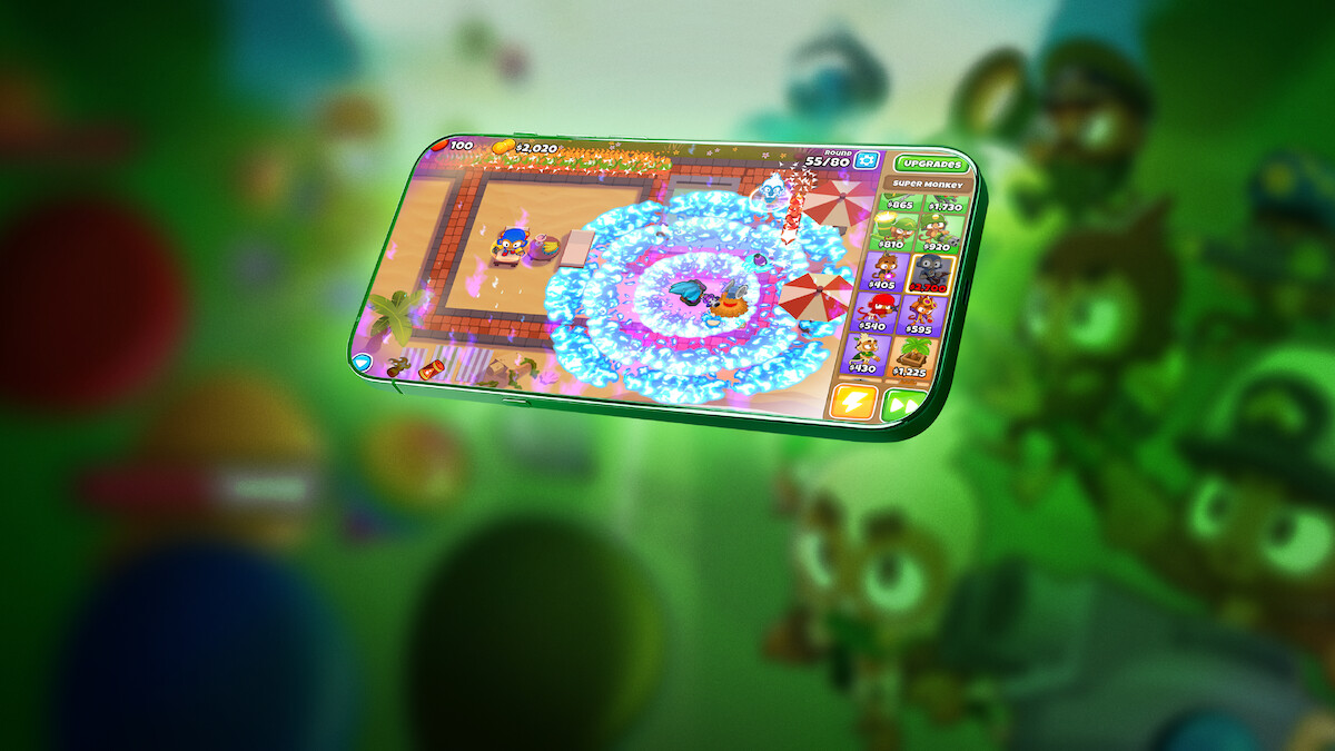 An in-game screenshot from the mobile game ‘Bloons TD 6,’ embedded within a floating phone screen.