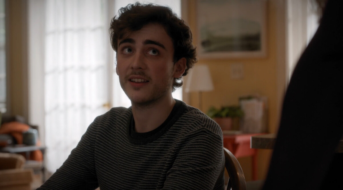 A man looks up with a hopeful expression to a person off-screen