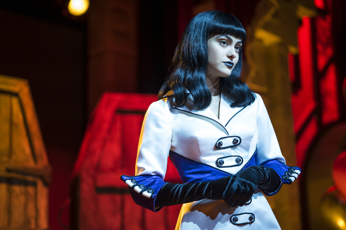 Camila Mendes as Veronica Lodge wears a white coat with long black gloves in Season 7 of ‘Riverdale.’