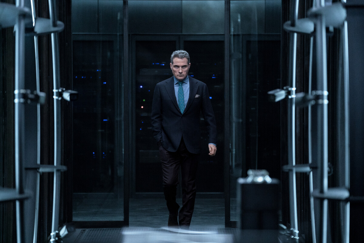 A man walking through a vault door.