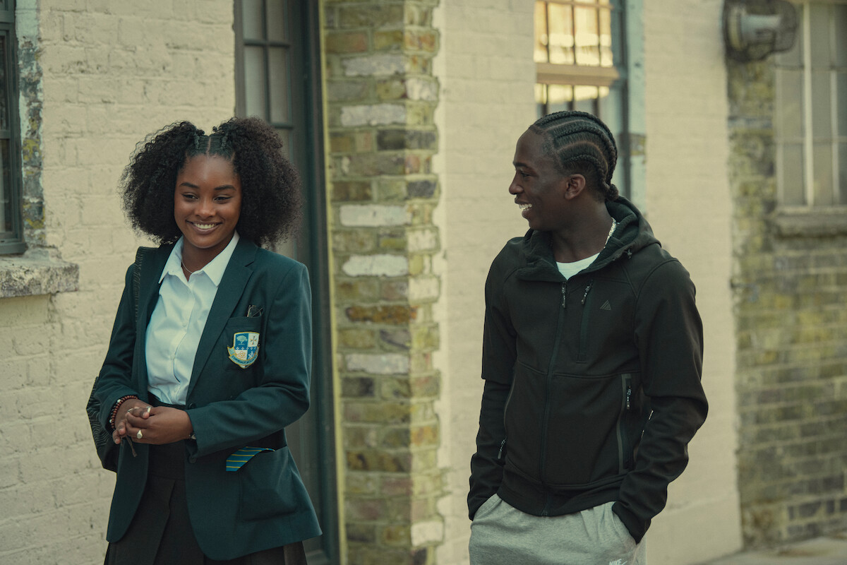 Savanah Graham as Erin and Araloyin Oshunremi as Stefan smile together as they walk down the street in Season 3 of ‘Top Boy.’