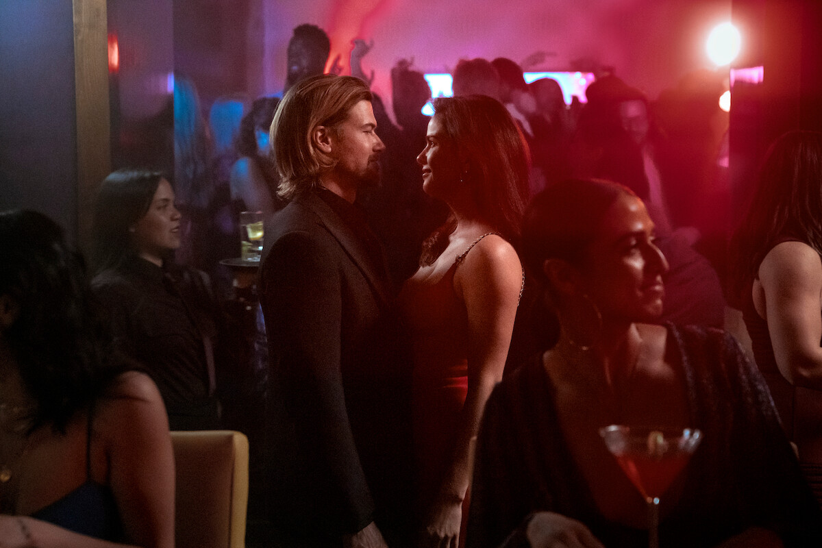 Nick Zano as Chad McKnight and Shelley Hennig as Ava Winters stand facing each other in a club in Season 1 of ‘Obliterated’