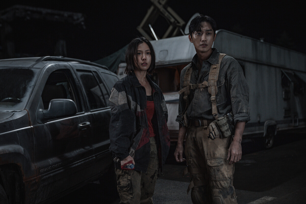 Go Min-si as Lee Eun-yu and Jinyoung as Park Chan-yeong stand outdoors at night in Season 3 of ‘Sweet Home’